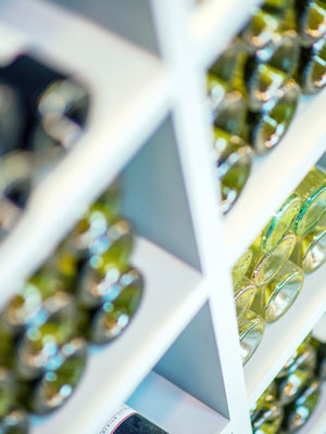 Ein Weinregal mit verschiedenen Flaschen zeigt auf die große Weinauswahl in unserem Onlineshop